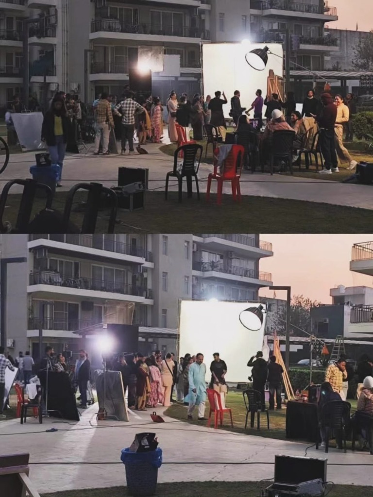 Film crew managing lights and actors during outdoor film shoot